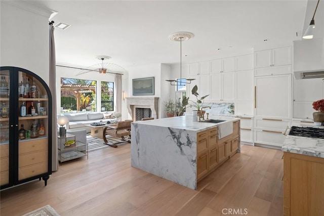 1115 Myles Ln, Nipomo, CA 93444 - kitchen featuring light wood finished floors, light stone counters, a fireplace, decorative light fixtures, and open floor plan
