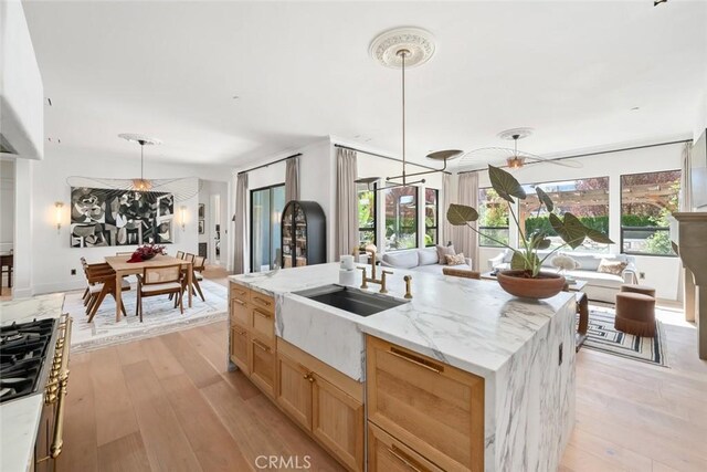 1115 Myles Ln, Nipomo, CA 93444 - kitchen with plenty of natural light, light wood-style flooring, hanging light fixtures, and a center island with sink
