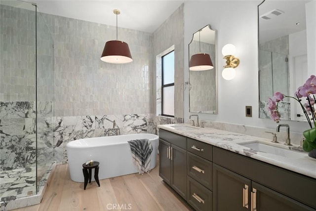 1115 Myles Ln, Nipomo, CA 93444 - bathroom featuring tile walls, a freestanding bath, tiled shower, double vanity, and wood finished floors