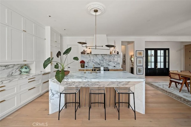 1115 Myles Ln, Nipomo, CA 93444 - kitchen with backsplash, white cabinetry, a breakfast bar, and ornamental molding
