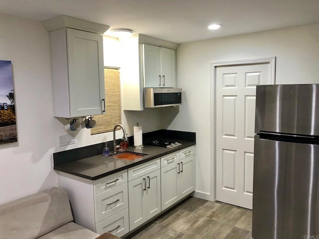 1009 S Cleveland St, Oceanside, CA 92054 - kitchen featuring appliances with stainless steel finishes, dark countertops, wood finished floors, recessed lighting, and white cabinetry