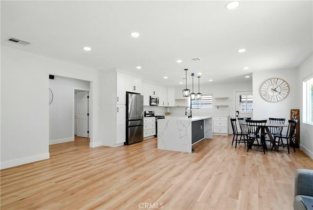 149 N Vail Ave, Montebello, CA 90640 - kitchen featuring appliances with stainless steel finishes, recessed lighting, light countertops, light wood-style flooring, and white cabinets