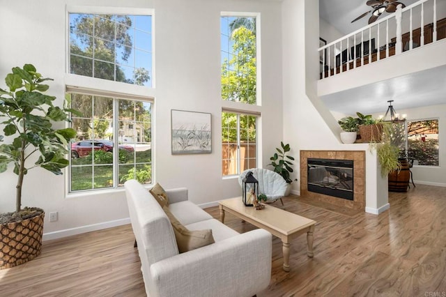 3430 Corte Viejo, Carlsbad, CA 92009 - living area featuring a high ceiling, wood finished floors, a tiled fireplace, ceiling fan, and a chandelier