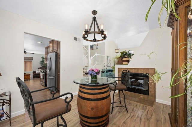 3430 Corte Viejo, Carlsbad, CA 92009 - dining space with wood finished floors, a chandelier, stairway, and a tile fireplace