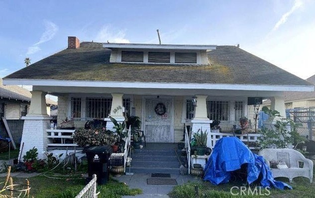 1336 W 46th St, Los Angeles, CA 90037 - bungalow-style house with covered porch, a chimney, and a shingled roof