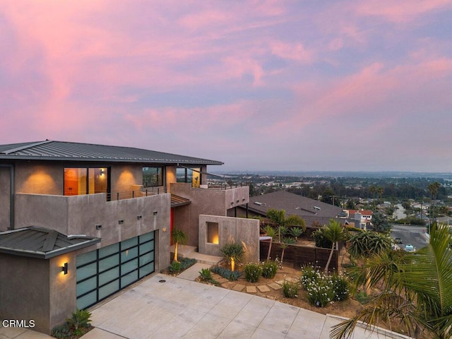 572 Skyline Rd, Ventura, CA 93003 - modern home with a balcony, driveway, a garage, stucco siding, and a metal roof