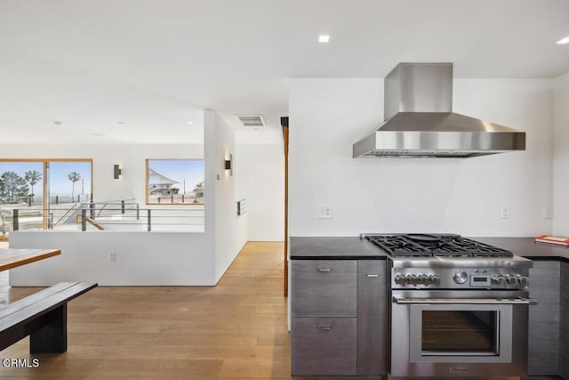 572 Skyline Rd, Ventura, CA 93003 - kitchen featuring wall chimney exhaust hood, high end stainless steel range oven, dark countertops, light wood-style flooring, and recessed lighting