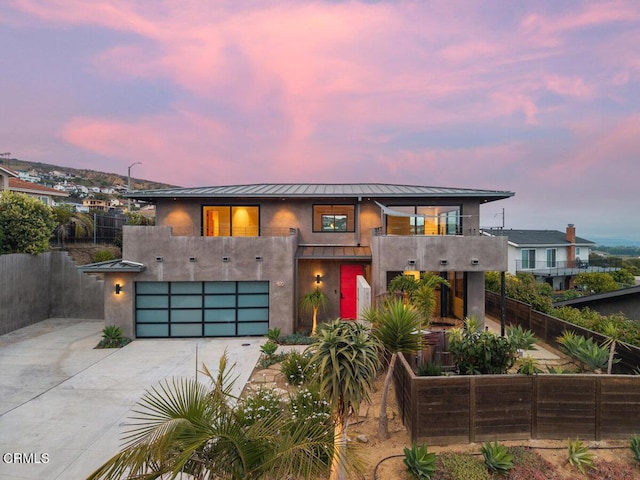 572 Skyline Rd, Ventura, CA 93003 - modern home featuring a standing seam roof, a balcony, stucco siding, driveway, and an attached garage