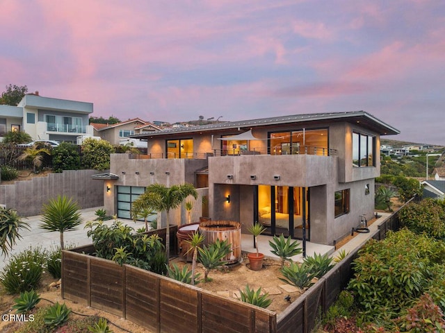 572 Skyline Rd, Ventura, CA 93003 - back of house at dusk with a balcony, a patio area, a fenced backyard, and stucco siding