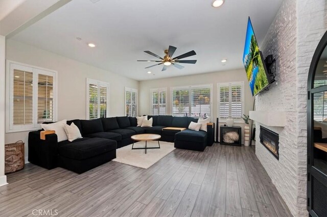 2516 Chad Zeller Ln, Corona, CA 92882 - living room with wood finished floors, ceiling fan, a stone fireplace, healthy amount of natural light, and recessed lighting