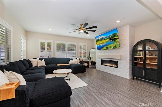 2516 Chad Zeller Ln, Corona, CA 92882 - living room featuring a glass covered fireplace, ceiling fan, wood finished floors, and recessed lighting