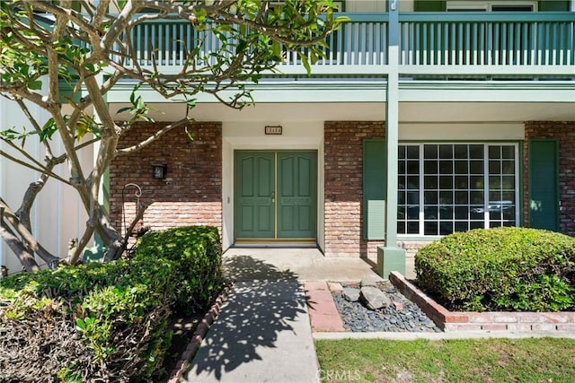 18684 Santa Ynez St, Fountain Valley, CA 92708 - doorway to property featuring brick siding, a balcony, and a porch