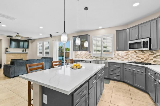 1702 Brezar St, Chula Vista, CA 91913 - kitchen with stainless steel microwave, gas cooktop, tasteful backsplash, gray cabinetry, and recessed lighting