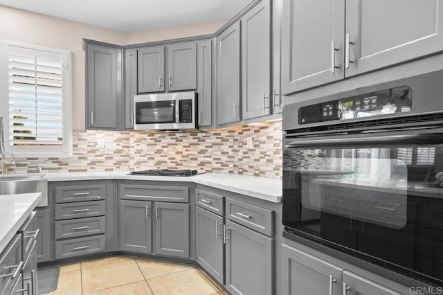 1702 Brezar St, Chula Vista, CA 91913 - kitchen with gray cabinets, oven, and stainless steel microwave