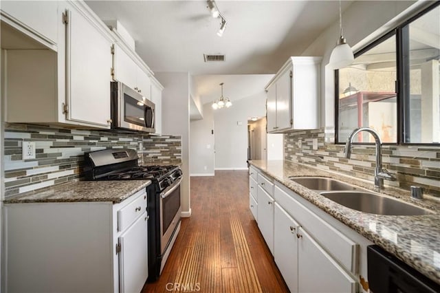 41015 163rd St E, Lancaster, CA 93535 - kitchen with appliances with stainless steel finishes, dark wood finished floors, white cabinetry, and decorative backsplash