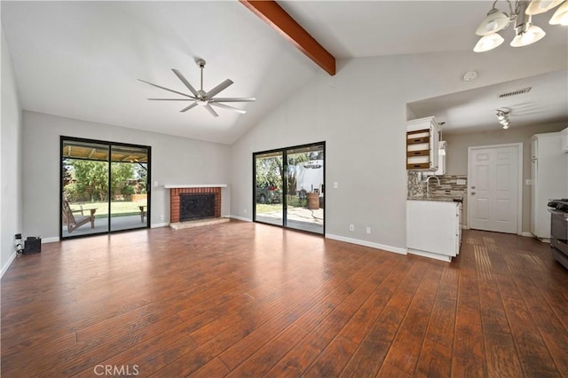 41015 163rd St E, Lancaster, CA 93535 - unfurnished living room featuring a ceiling fan, beamed ceiling, dark wood-type flooring, plenty of natural light, and high vaulted ceiling