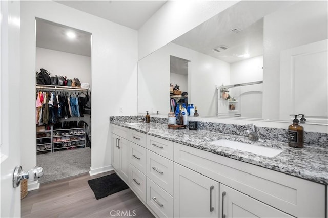12366 Ranchito Way, Victorville, CA 92392 - bathroom with double vanity, a spacious closet, wood finished floors, and a shower