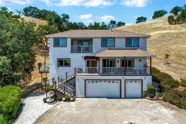 4445 Eucalyptus Ave, Lakeport, CA 95453 - view of front of home with driveway, an attached garage, stairway, a balcony, and stucco siding