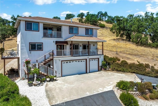 4445 Eucalyptus Ave, Lakeport, CA 95453 - view of front of home with a balcony, a garage, stairway, concrete driveway, and stucco siding