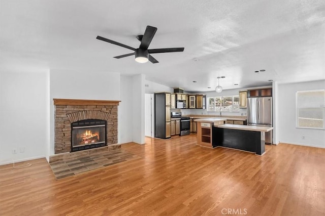 1225 N Alessandro St, Banning, CA 92220 - kitchen with stainless steel appliances, a center island, light countertops, and light wood-style flooring