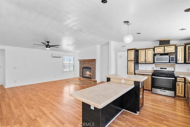 1225 N Alessandro St, Banning, CA 92220 - kitchen featuring stainless steel appliances, light countertops, a kitchen island, and light wood-style flooring