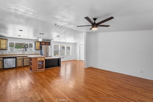1225 N Alessandro St, Banning, CA 92220 - kitchen with stainless steel appliances, open floor plan, light countertops, wood finished floors, and a kitchen island