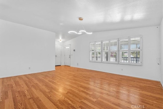 1225 N Alessandro St, Banning, CA 92220 - empty room featuring a chandelier, lofted ceiling, and light wood-type flooring
