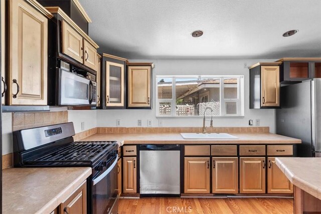 1225 N Alessandro St, Banning, CA 92220 - kitchen with stainless steel appliances, light countertops, light wood finished floors, and glass insert cabinets