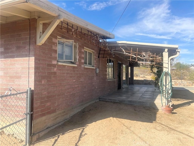 6124 El Reposo St, Joshua Tree, CA 92252 - view of side of property featuring a patio area and brick siding