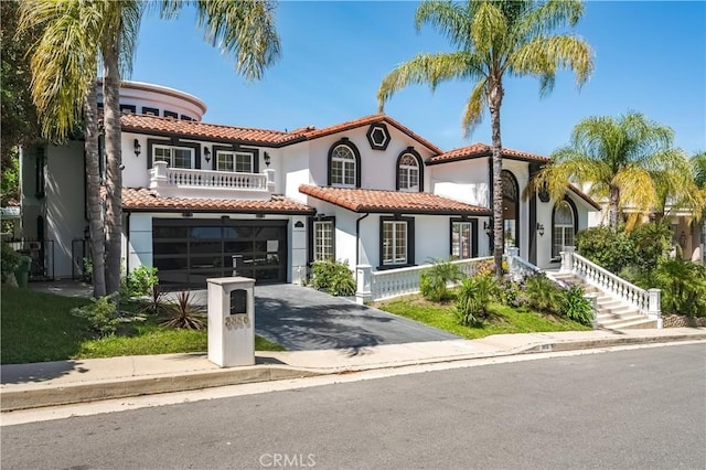 3856 Vista Linda Dr, Encino, CA 91316 - mediterranean / spanish house with driveway, stucco siding, a tile roof, a garage, and a balcony