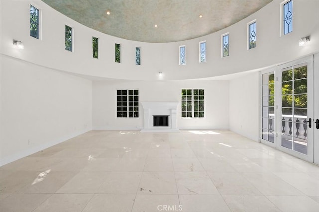 3856 Vista Linda Dr, Encino, CA 91316 - unfurnished living room featuring a high ceiling, plenty of natural light, a glass covered fireplace, and recessed lighting
