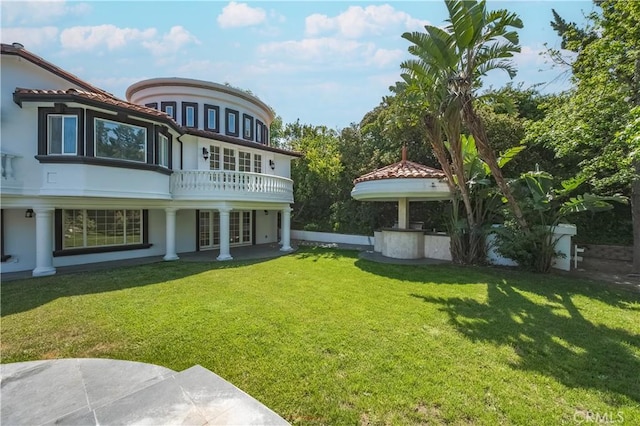 3856 Vista Linda Dr, Encino, CA 91316 - back of house with stucco siding, a lawn, and a balcony