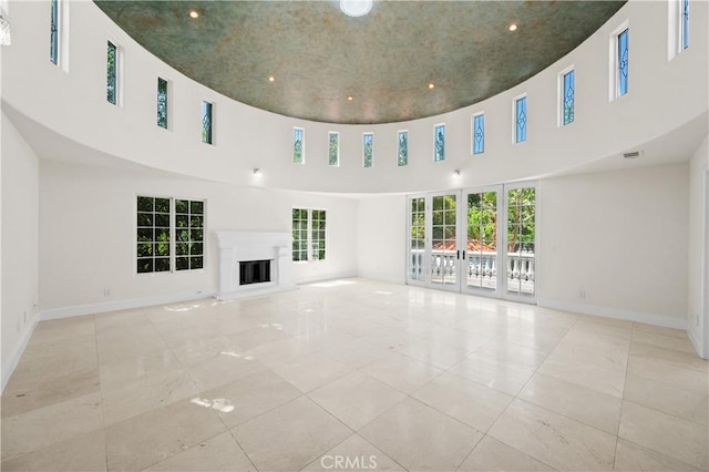 3856 Vista Linda Dr, Encino, CA 91316 - unfurnished living room featuring marble look tile flooring, a high ceiling, a glass covered fireplace, and recessed lighting