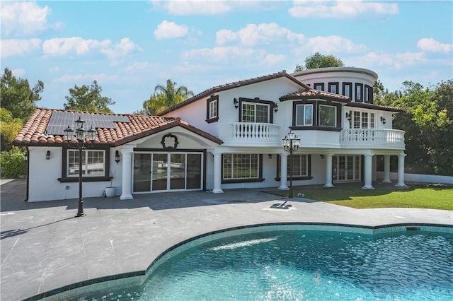 3856 Vista Linda Dr, Encino, CA 91316 - rear view of house with a balcony, solar panels, a patio, an outdoor pool, and a tile roof