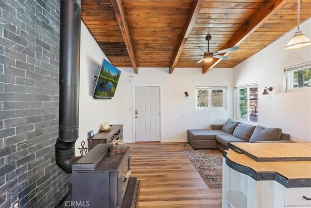 1946 Desert Front Rd, Wrightwood, CA 92397 - living area with a ceiling fan, a wood stove, wood finished floors, and a wooden ceiling with exposed beams