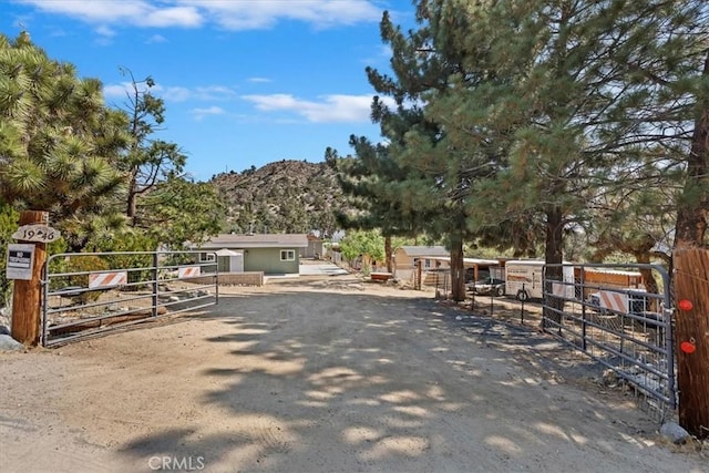 1946 Desert Front Rd, Wrightwood, CA 92397 - view of front facade featuring a mountain view, an outdoor structure, and a gate
