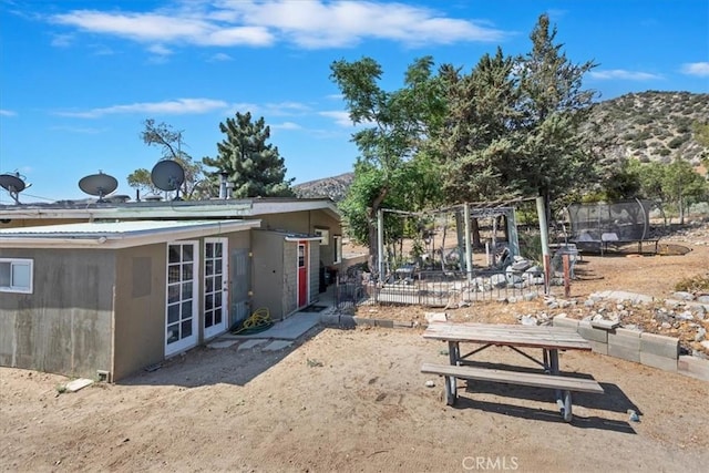 1946 Desert Front Rd, Wrightwood, CA 92397 - view of yard featuring a trampoline, french doors, and a mountain view