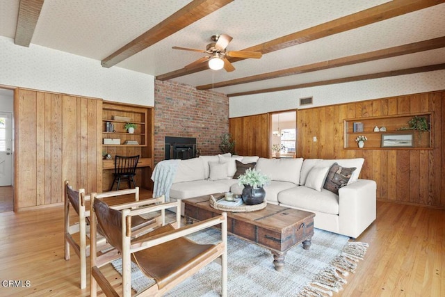 410 Palomares Ave, Ventura, CA 93003 - living area featuring beam ceiling, wood walls, light wood-style floors, a ceiling fan, and a wood stove