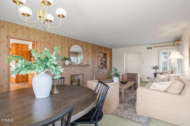 410 Palomares Ave, Ventura, CA 93003 - dining area with wooden walls, a chandelier, a fireplace, and carpet floors