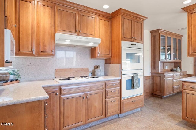 410 Palomares Ave, Ventura, CA 93003 - kitchen with white appliances, under cabinet range hood, brown cabinets, tasteful backsplash, and recessed lighting