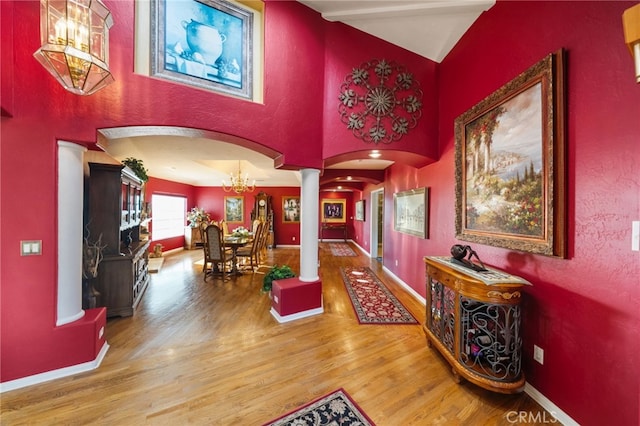 40115 Via Cordova, Temecula, CA 92592 - hallway with arched walkways, ornate columns, wood finished floors, a chandelier, and high vaulted ceiling