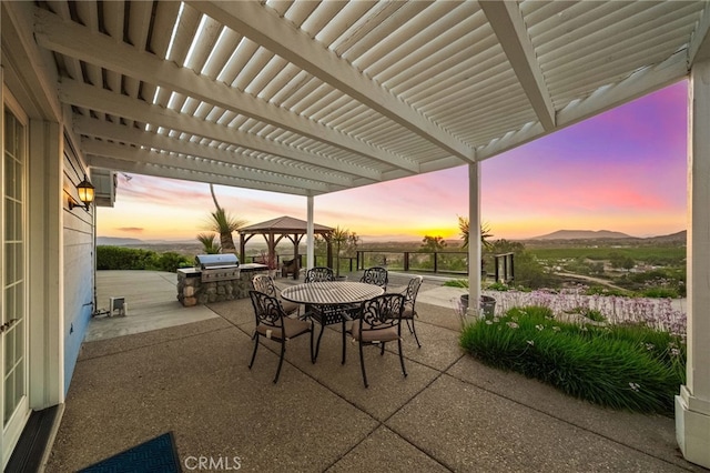 40115 Via Cordova, Temecula, CA 92592 - patio terrace at dusk featuring outdoor dining area, a pergola, area for grilling, a patio area, and a mountain view