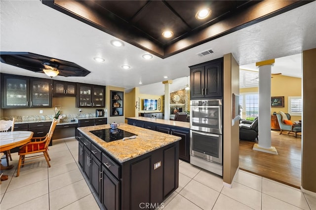 40115 Via Cordova, Temecula, CA 92592 - kitchen featuring decorative columns, black electric cooktop, a raised ceiling, stainless steel double oven, and a center island