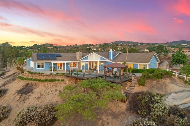 40115 Via Cordova, Temecula, CA 92592 - rear view of house with a gazebo, roof mounted solar panels, a deck with mountain view, french doors, and a chimney