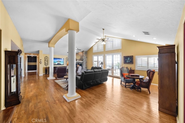 40115 Via Cordova, Temecula, CA 92592 - living room with a stone fireplace, ornate columns, a ceiling fan, wood finished floors, and lofted ceiling