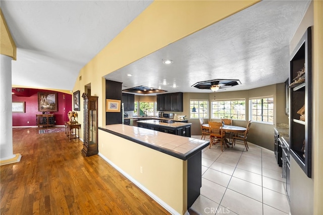 40115 Via Cordova, Temecula, CA 92592 - kitchen featuring tile countertops, a peninsula, wood finished floors, and ceiling fan