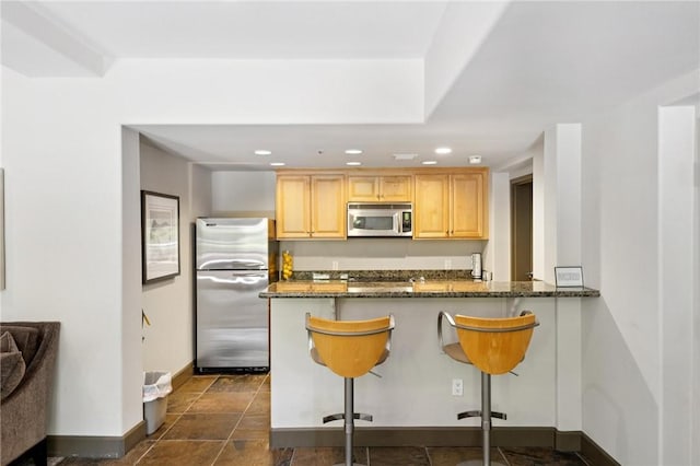 1800 Alma Ave Unit 106, Walnut Creek, CA 94596 - kitchen with stainless steel appliances, light brown cabinetry, a kitchen breakfast bar, dark stone countertops, and recessed lighting