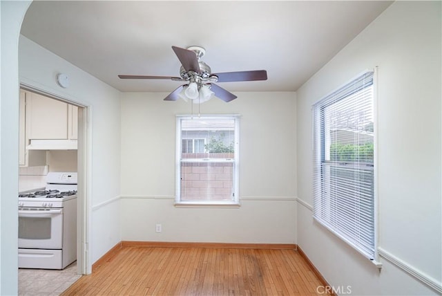 2124 Rutgers Ave, Long Beach, CA 90815 - unfurnished dining area with a ceiling fan, light wood-style flooring, and arched walkways
