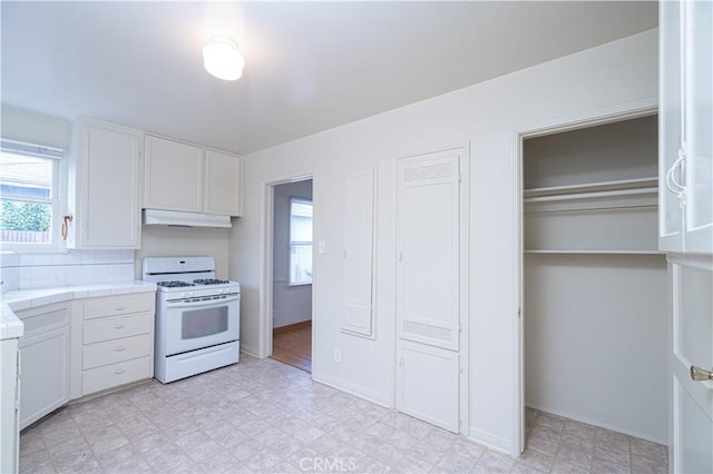 2124 Rutgers Ave, Long Beach, CA 90815 - kitchen with white range with gas cooktop, tile counters, under cabinet range hood, white cabinetry, and light flooring