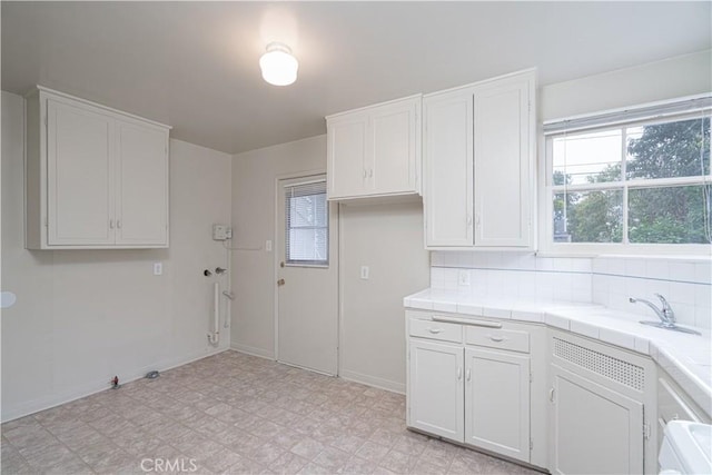 2124 Rutgers Ave, Long Beach, CA 90815 - kitchen with tile counters, white cabinetry, and light flooring